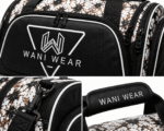 Close-up of Wani Wear duffel bag showing the embroidered logo, premium zipper hardware, heavy-duty strap clips, and padded handle with branding.