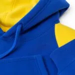 Close-up of a custom blue and yellow basketball hoodie with drawcord and reinforced stitching