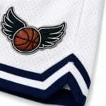 Embroidered basketball patch and reinforced stitching on custom white mesh basketball shorts