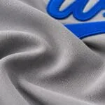 Reinforced sleeve stitching and royal blue piping on custom grey baseball jersey