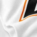 Custom baseball T-shirt fabric close-up showing soft white material and high-quality black-and-orange print