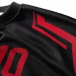 Breathable moisture-wicking polyester fabric close-up of a black and red custom baseball jersey
