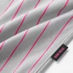 Grey baseball pants fabric with pink pinstripes close-up