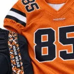 Orange custom American football jersey fabric and stitching close-up