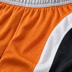 Close-up of breathable orange and white mesh fabric on customized lacrosse shorts