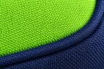 Close-up of lime green and navy woven polyester fabric with contrast piping on youth sports duffle bag