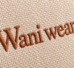Close-up of tonal brown embroidered logo on custom canvas duffle bag