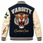 Back of a navy varsity jacket with arched VARSITY lettering, embroidered roaring tiger head and gold Custom Crew script