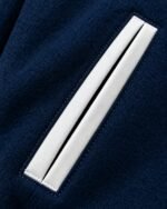 White-piped welt pocket detail on navy wool football varsity jacket