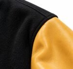 Black wool body and gold leather sleeve seam detail on a custom varsity jacket