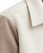 Shirt collar and shoulder seam detail on custom cream and taupe wool varsity jacket