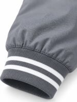 Close-up of grey and white striped rib-knit cuff on bulk bomber jacket