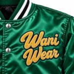 Close-up of chenille patch on custom satin varsity jacket with black satin lining and striped collar