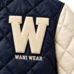 Close-up of cream chenille letter patch and embroidered logo on quilted letterman jacket