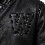Close-up of stitched leather W appliqué patch with embroidered Wani Wear logo