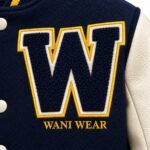 Close-up of navy chenille letter W patch with gold and cream felt border on custom varsity jacket