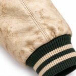 Distressed cream leather sleeve with green and cream striped rib knit cuff detail