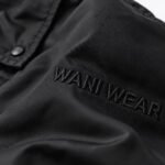 Close-up of tonal 3D embroidered logo on a black private label coach jacket