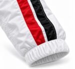 Close-up of red and black racing stripes and elastic cuff on a white custom racing coach jacket