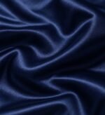 Close-up of glossy navy satin fabric used for custom souvenir jackets