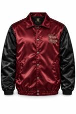 Front view of two-tone burgundy and black satin coach jacket with snap buttons and embroidered script logo