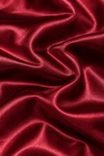 Close-up of glossy burgundy satin fabric used for custom satin coach jackets