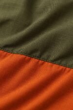 Ripstop fabric close-up of a two-tone olive and orange custom coach jacket colorblock seam