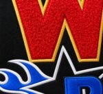 Close-up of red chenille W letter with gold border and blue flame star embroidery