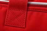 Close-up of box-X reinforced red webbing handle stitching and silver zipper on custom cheer duffle bag