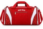 End view of red cheerleading duffel bag showing zippered shoe compartment, white piping and mesh bottle pocket
