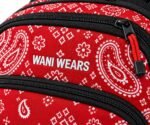 Close-up of white Wani Wears embroidery and red paracord zipper puller on red paisley bandana print fabric