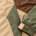 Ripstop windbreaker close-up of color block panel stitching and Velcro cuff tab – Wani Wear